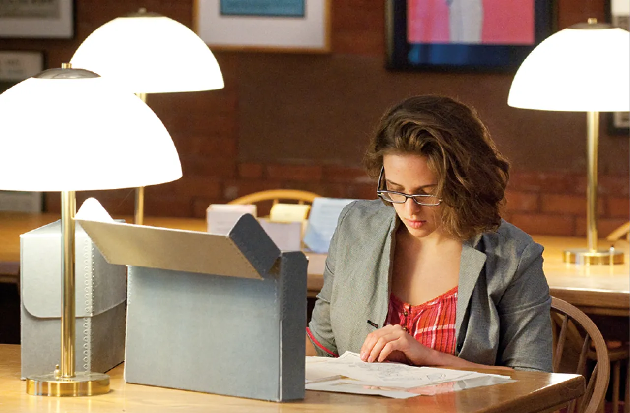 Student working with papers at a table in the college archives