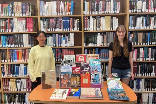 Students with graphic novel display in Josten Library