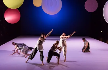 Four dances onstage with a backdrop of colored circles