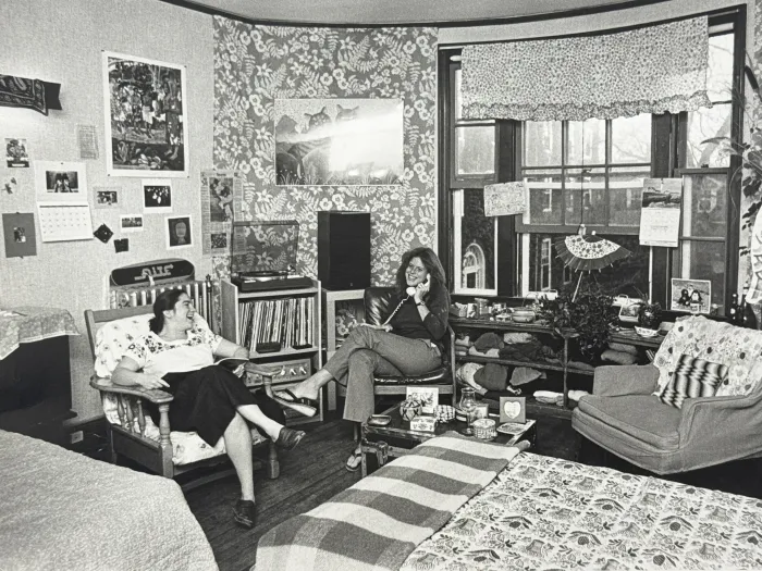 Students sitting in chairs in dorm room