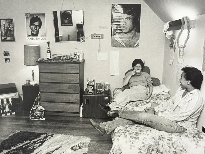 Students sitting on bed in dorm room
