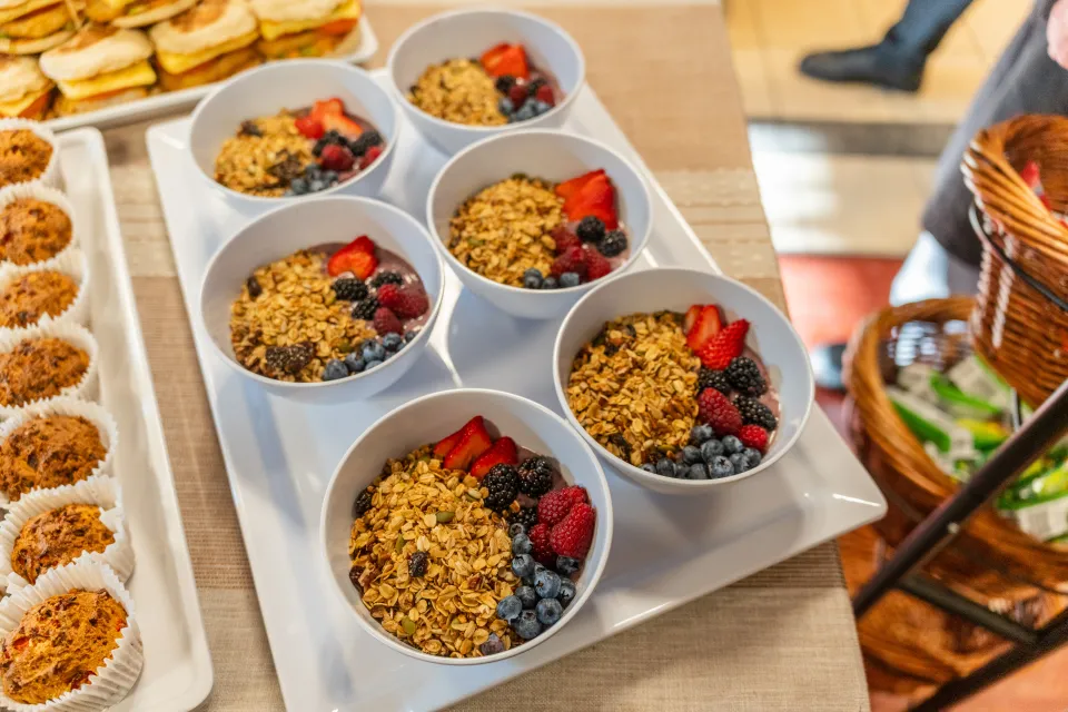Bowls of berry smoothie with pecan granola and fresh berries