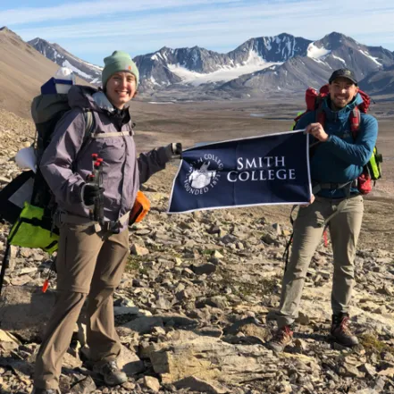 Sarah Bragdon and Professor Greg de Wet in Norway, holding a Smith College flag.