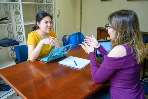 A student and writing tutor discussing a paper.