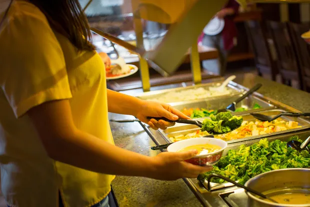Closeup of a student making selections from a salad bar